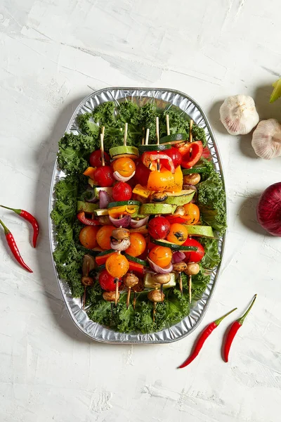 Vegetariánské špejle se suchými bylinkami na dřevěných špejlích z cibule cukety na talíři — Stock fotografie