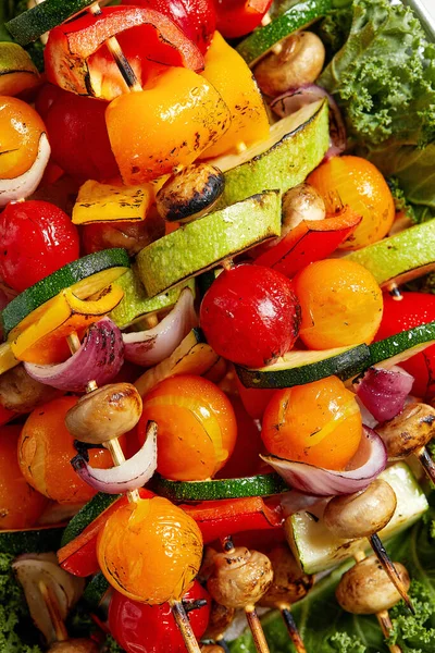 Espetos vegetarianos com ervas secas em espetos de madeira de cogumelos de cebola de tomate de abobrinha em uma chapa — Fotografia de Stock