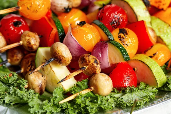 Vegetarische Spieße mit trockenen Kräutern auf hölzernen Spießen aus Zucchini-Tomaten-Zwiebelpilzen auf einem Teller — Stockfoto