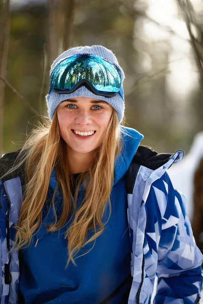Beeld met een portret van een vrouwelijke snowboarder die een helm draagt met een heldere reflectie in de bril. Op de achtergrond van hoge sneeuwberg — Stockfoto