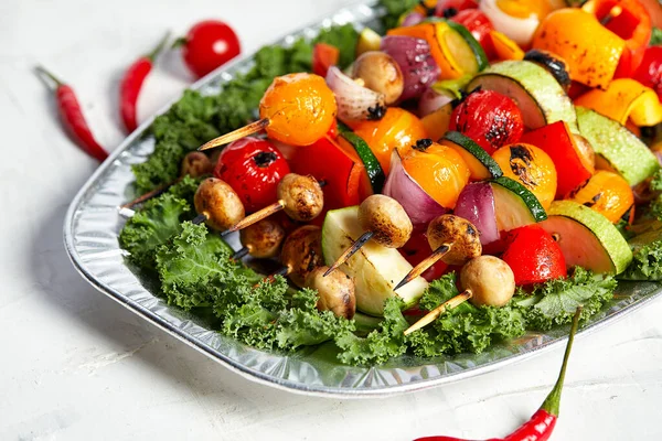 Vegetarische Spieße mit trockenen Kräutern auf hölzernen Spießen aus Zucchini-Tomaten-Zwiebelpilzen auf einem Teller — Stockfoto