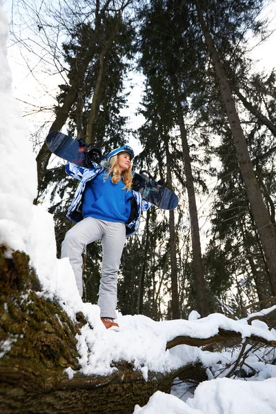 Imagem com um retrato de uma snowboarder feminina usando um capacete com um reflexo brilhante nos óculos. No fundo da montanha de neve alta — Fotografia de Stock