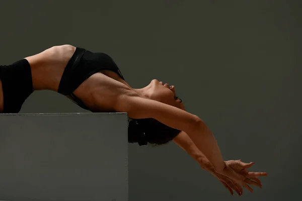 Συναισθηματικός χορευτής γυναικείων μπαλέτου στο κοστούμι του σώματος και ποζάρισμα στο χορό σε διάφορες στάσεις σε γκρι φόντο — Φωτογραφία Αρχείου