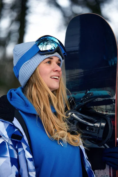 Immagine con il ritratto di una donna snowboarder che indossa un casco con un riflesso luminoso negli occhiali. Sullo sfondo di alta montagna di neve — Foto Stock