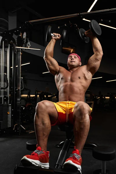Bodybuilder knappe sterke atletische ruwe man pompen buikspieren fitness en bodybuilding gezonde concept achtergrond — Stockfoto