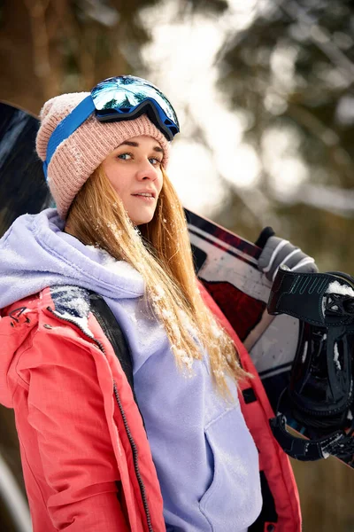 Close up retrato da mulher snowboarder na estância de esqui usando capacete e óculos com reflexo da floresta nas montanhas. Espaço livre da cópia para suas informações. — Fotografia de Stock