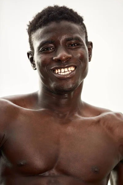 Hombre africano sonriendo después del entrenamiento. Está en un parque.. — Foto de Stock