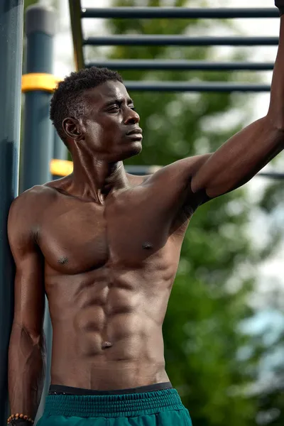 Afrikaner lächelt nach dem Training. Er ist in einem Park. — Stockfoto