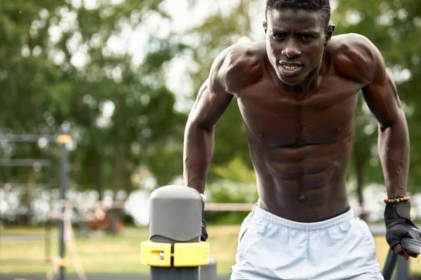 Entrenando por la mañana. Joven hombre africano fuerte en ropa deportiva haciendo ejercicio al aire libre. Deporte, concepto de entrenamiento. Vida activa saludable. TRX — Foto de Stock
