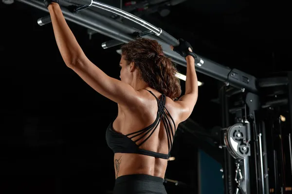 Ελκυστική γυναίκα ταιριάζει λειτουργεί έξω με αλτήρες ως εννοιολογική γυμναστήριο πάνω από σκούρο φόντο. — Φωτογραφία Αρχείου