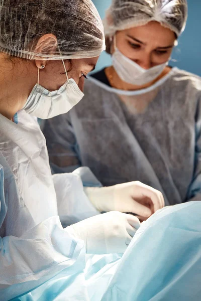 Équipe chirurgicale concentrée opérant un patient dans un bloc opératoire — Photo