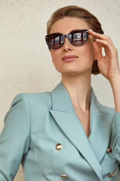 Hermosa joven con gafas de sol en una chaqueta de moda pasea por la ciudad. Retrato de estilo de vida al aire libre. — Foto de Stock