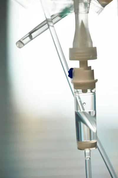 Fechar o tubo intravenoso. Acção. Dropper com droga lentamente gotejando tubo. Tubos IV para paciente doente após a cirurgia. — Fotografia de Stock