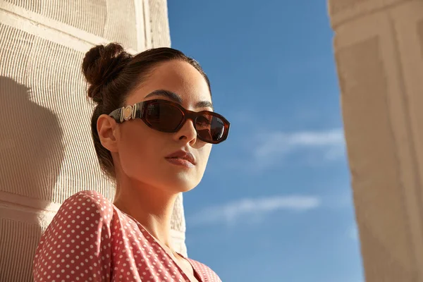 Un retrato de una hermosa mujer en gafas de sol contra el cielo azul — Foto de Stock