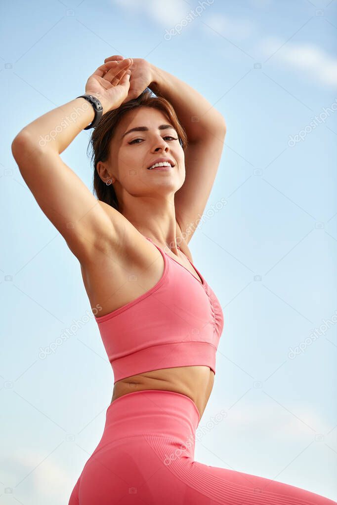 Attractive athletic woman exercising outdoors in the morning. Young beautiful woman with a slim figure goes in for sports at beach. Fitness, sport and healthy lifestyle concept.
