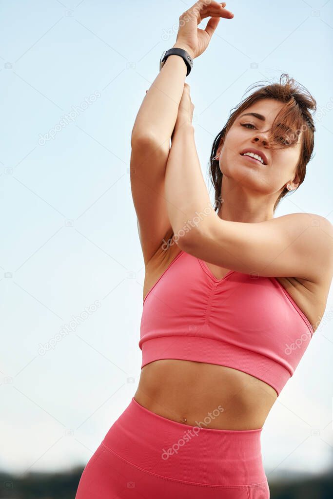 Attractive athletic woman exercising outdoors in the morning. Young beautiful woman with a slim figure goes in for sports at beach. Fitness, sport and healthy lifestyle concept.