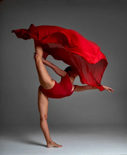 Bailarina saltando en zapatos de punta con paño rojo volador, danza moderna del ballet, fondo gris aislado — Foto de Stock