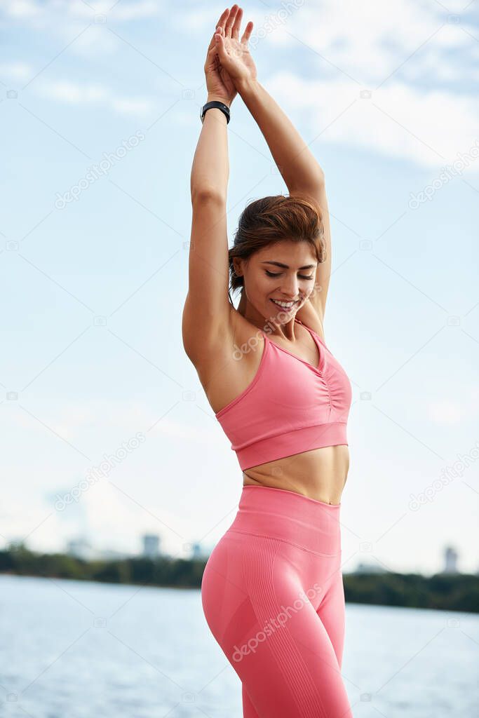 Attractive athletic woman exercising outdoors in the morning. Young beautiful woman with a slim figure goes in for sports at beach. Fitness, sport and healthy lifestyle concept.