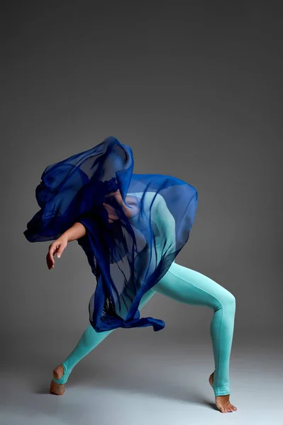 Bailarina bailando con tela de seda, bailarina de ballet moderna en tela ondulante, fondo gris — Foto de Stock