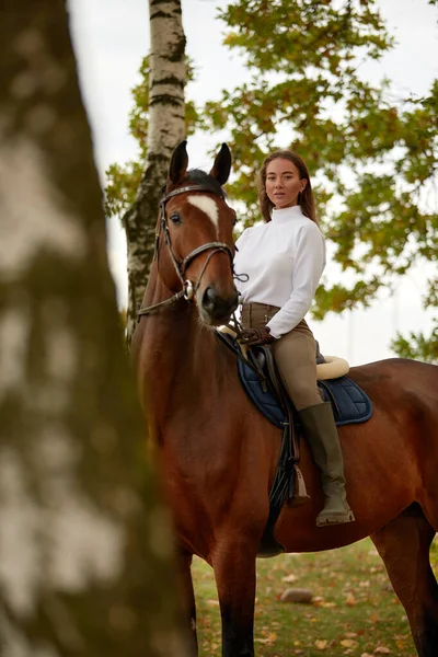 Όμορφη νεαρή γυναίκα ιππεύει ένα άλογο στο γήπεδο. Πλευρές προς την κάμερα. Ελευθερία, χαρά, κίνηση — Φωτογραφία Αρχείου
