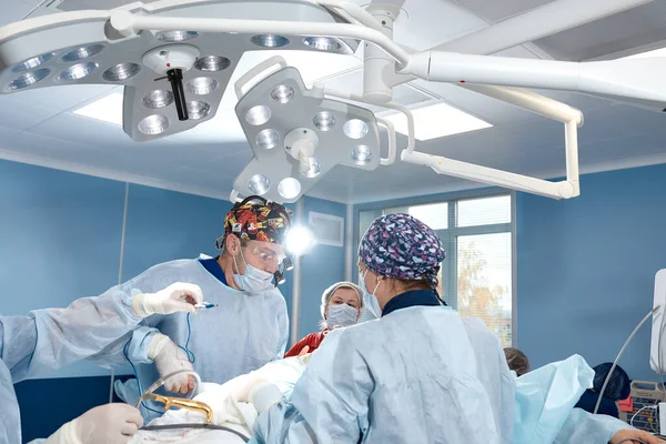 Chirurg s asistentkou operuje na ženském prsu, mammoplastice, prsní onkologii. — Stock fotografie