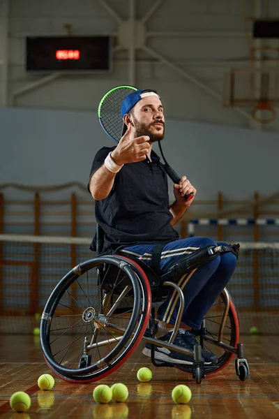 휠체어를 타고 법정에서 테니스를 치고 있는 청년 — 스톡 사진