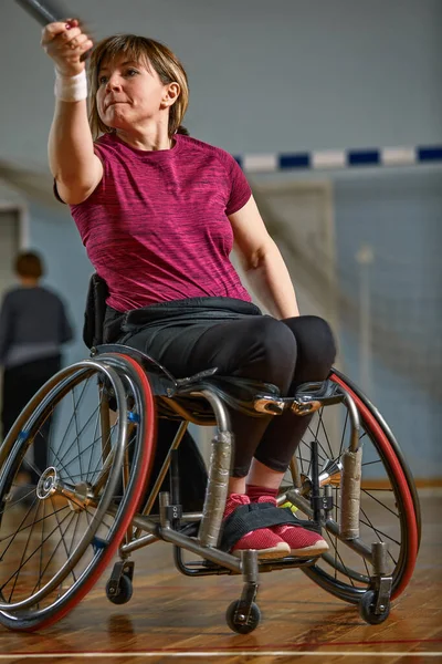 휠체어를 타고 테니스 코트에서 테니스를 치고 있는 젊은 여자 — 스톡 사진