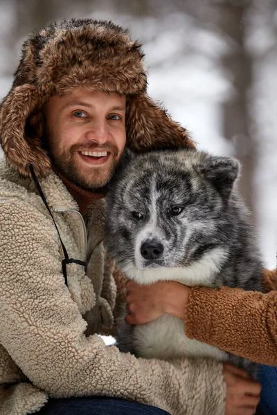 Hombres jugando con husky siberiano en bosque y parque invernal, animales y ecología —  Fotos de Stock