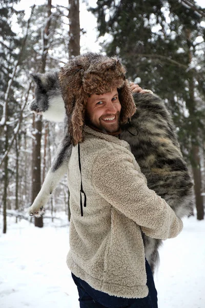 Hombres jugando con husky siberiano en bosque y parque invernal, animales y ecología — Foto de Stock