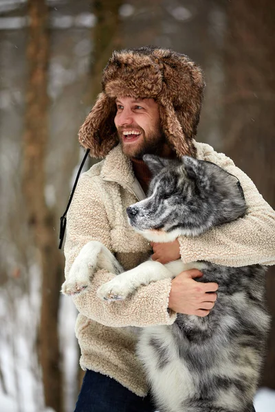 Homens brincando com husky siberiano na floresta de inverno e parque, animais e ecologia — Fotografia de Stock