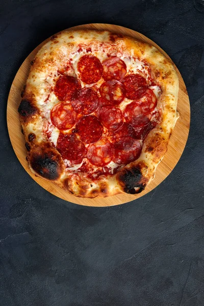 Pizza de pepperoni saboroso no fundo de concreto preto. Vista superior da pizza de pepperoni quente. Com espaço de cópia para texto. — Fotografia de Stock