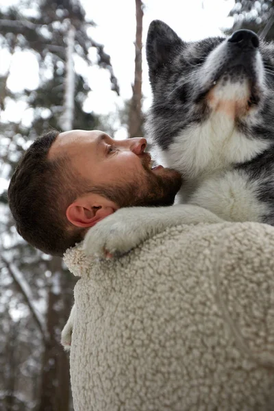 Muži hrají se sibiřským husky v zimním lese a parku, zvířata a ekologie. Milovník zvířat. Pes - lidský přítel koncept — Stock fotografie