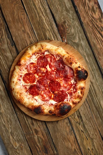 Піца Пепероні на дерев'яному фоні сільського, вінтажного стилю. Вид зверху — стокове фото