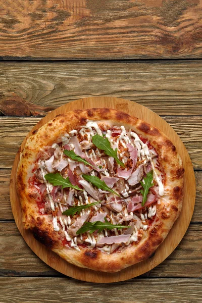 Neapolitan Pizza with Mozzarella cheese, bacon, ham, tomato sauce, chicken, Spices and Fresh arugula. Italian pizza on wooden table background — Stock Photo, Image