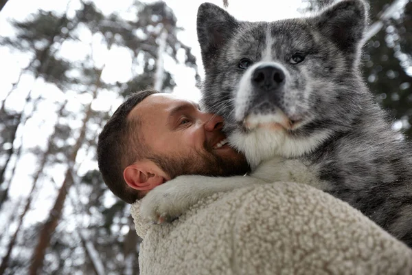 Szibériai huskyval játszó férfiak a téli erdőben és parkban, állatok és ökológia. Állatbarát. Kutya - emberi barát koncepció — Stock Fotó