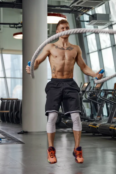 肌肉发达、强壮、有进取心的男子在功能训练健身馆用绳子进行训练.运动模糊 — 图库照片