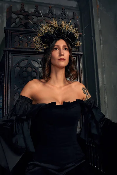 Portrait d'une belle jeune femme médiévale en robe noire en couronne élégante assise sur un trône. L'histoire du Moyen Âge — Photo