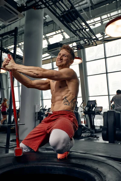 Männerfitness-Training mit großen und schweren Reifen schlägt Hammer. Konzept Workout, Cross-Kraft — Stockfoto