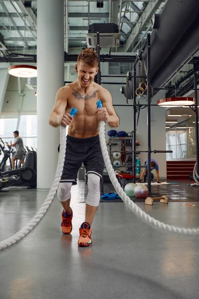 肌肉发达、强壮、有进取心的男子在功能训练健身馆用绳子进行训练.运动模糊 — 图库照片