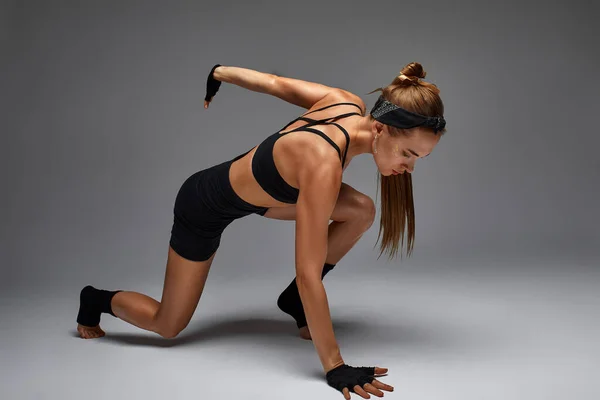 Retrato da raiva feminina, instinto animal, demonstrando sua incrível flexibilidade com o movimento do fluxo animal no estúdio em um fundo cinza. — Fotografia de Stock