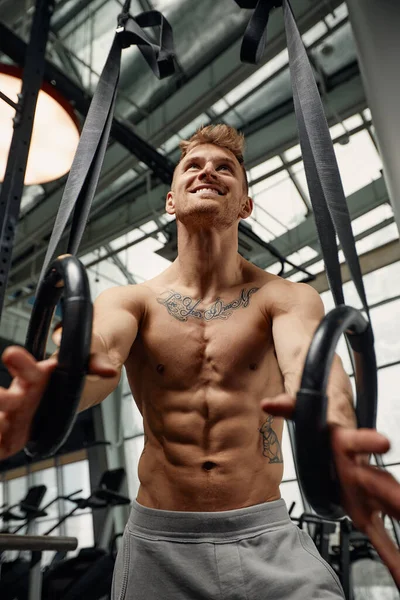 Muskeltraining junger Mann beim intensiven Cross-Fit-Training im Fitnessstudio an den Ringen. — Stockfoto