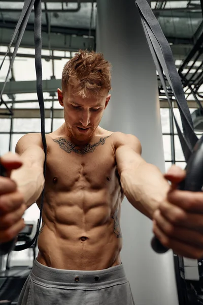 Stark man gör övning på Gymnastringar på gym. Fit manliga idrottare utbildning på Gymnastringar i ljus sporthall — Stockfoto