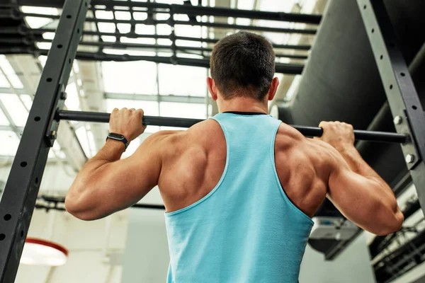 Douleur pendant l'exercice, travail avec son propre poids, l'athlète fait des exercices sur les barres inégales surmonter la douleur — Photo