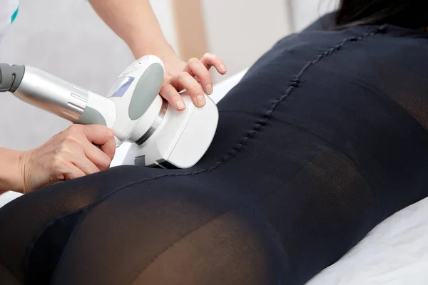 Woman receives LPG massage to remove cellulite from her body, for lifting legs. Concept beauty therapy in spa salon