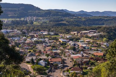 Etrafında evler ve ormanlar olan bir köy, Morro Reuter, Rio Grande do Sul, Brezilya