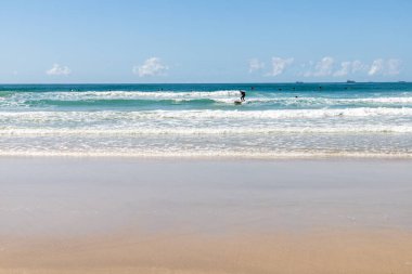 Dalgalarda, kumlarda ve dalgalarda sörfçüler, Praia do Rosa, Imbituba, Santa Catarina, Brezilya