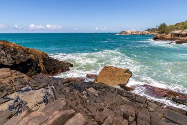Sahilde kayalar, dalgalar ve kum Praia da Barra, Garopaba, Santa Catarina, Brezilya