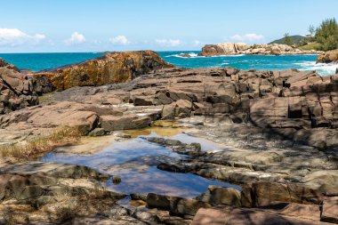 Sahilde kayalar, dalgalar ve kum Praia da Barra, Garopaba, Santa Catarina, Brezilya