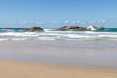 Sahilde kayalar, dalgalar ve kum Praia da Barra, Garopaba, Santa Catarina, Brezilya