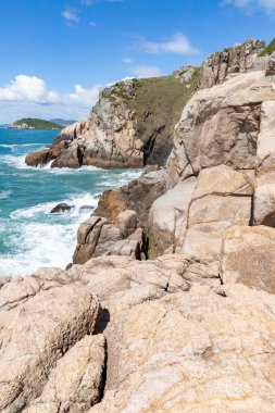 Kayalıklarda kayalar ve arka planda okyanus Praia do Rosa, Ibiraquera, Santa Catarina, Brezilya